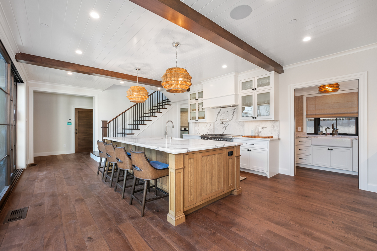 Coastal kitchen with reeded oak island, marble waterfall and woven pendants